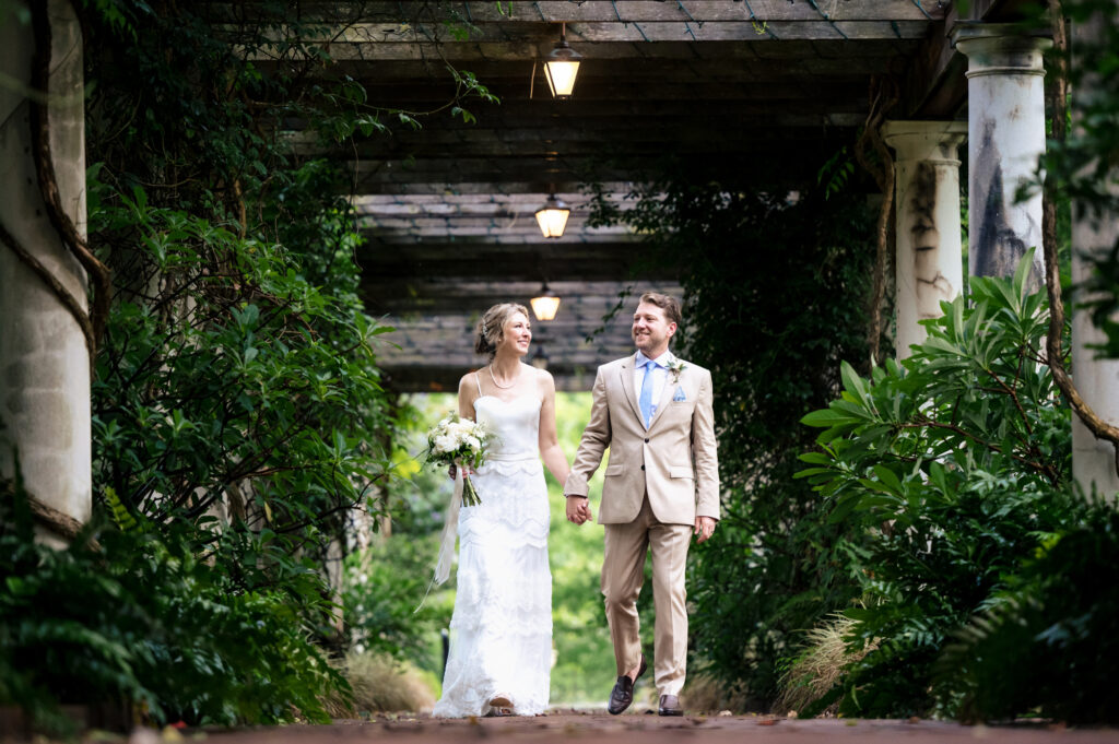 Bride and groom walking through a garden