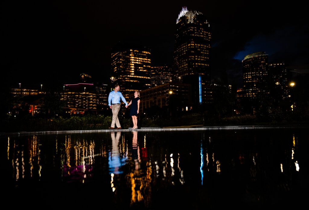 couple holding hands at night in first ward park charlotte north carolina