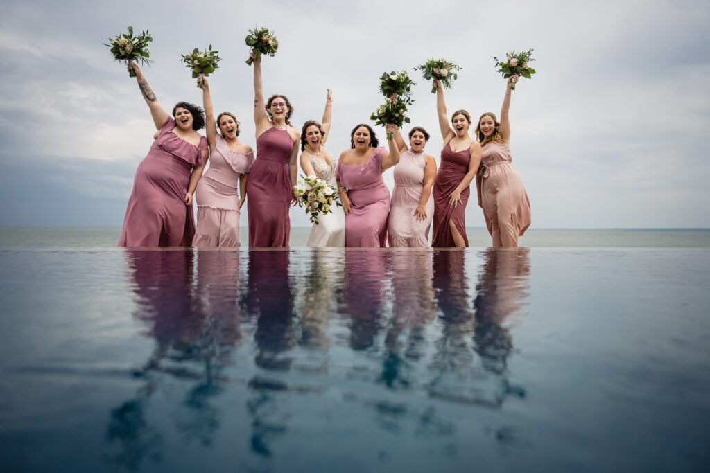 Bridesmaids reflected in an infinity pool