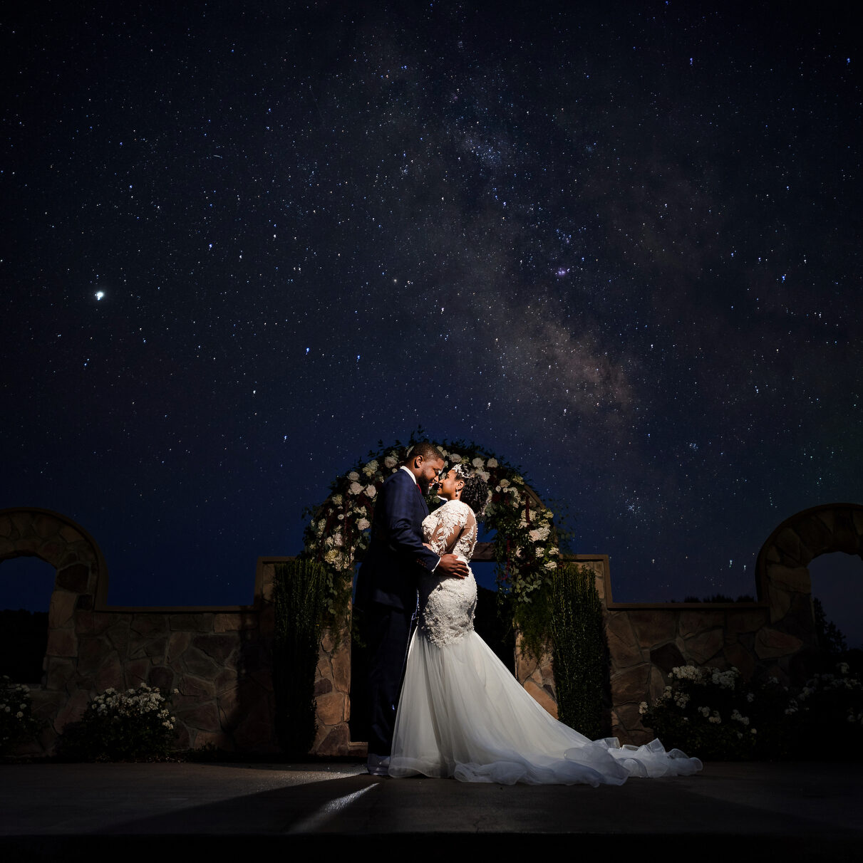 Bride and Groom holding each other with the stars and skies above them